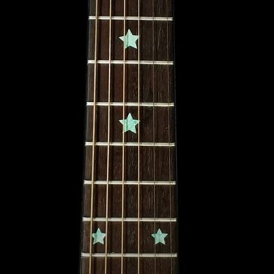 Vista detallada de las marcas del diapasón con patrón de estrellas